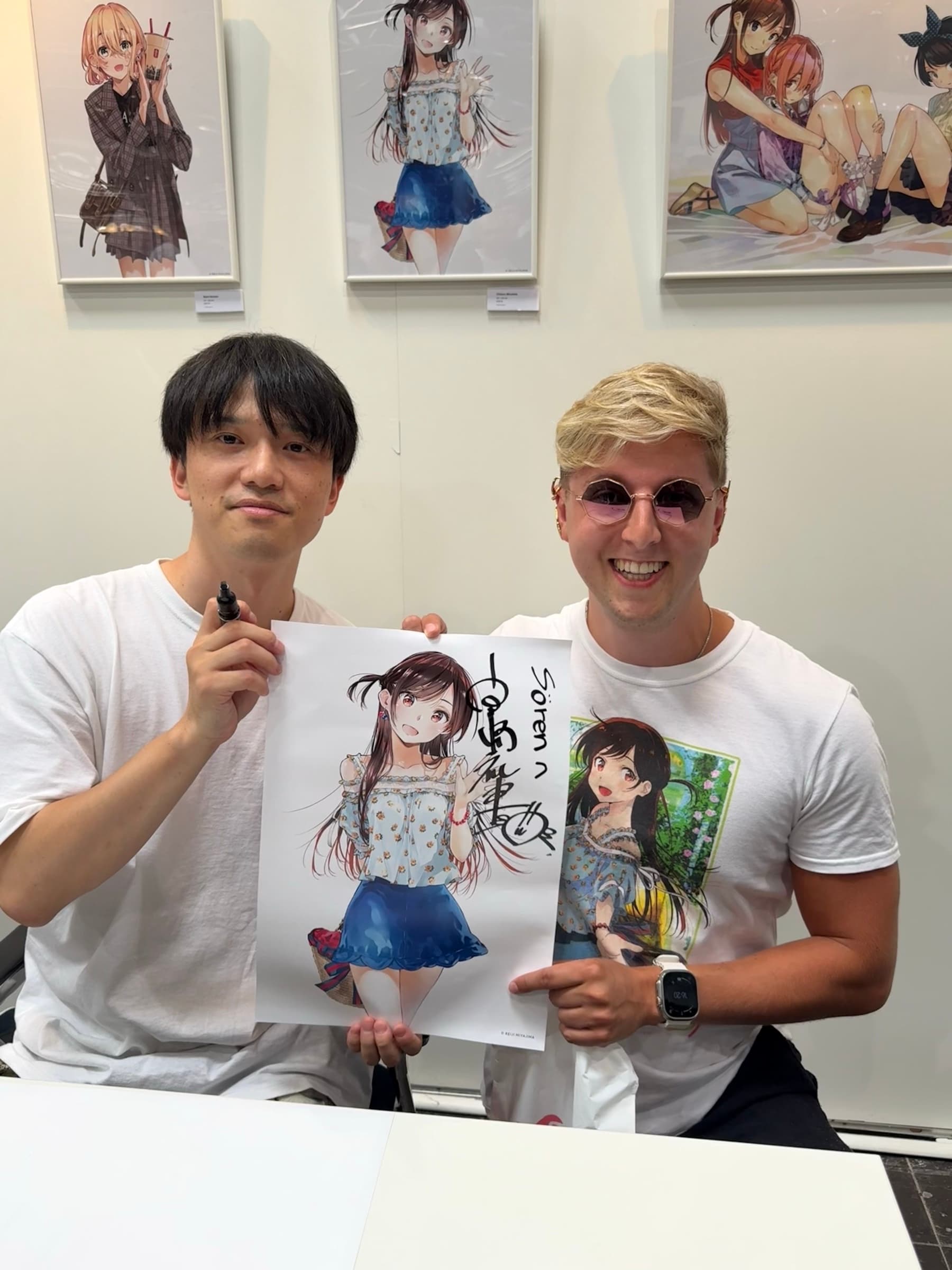 Sören Creutzburg with Reiji Miyajima holding signed Rent-A-Girlfriend artwork.